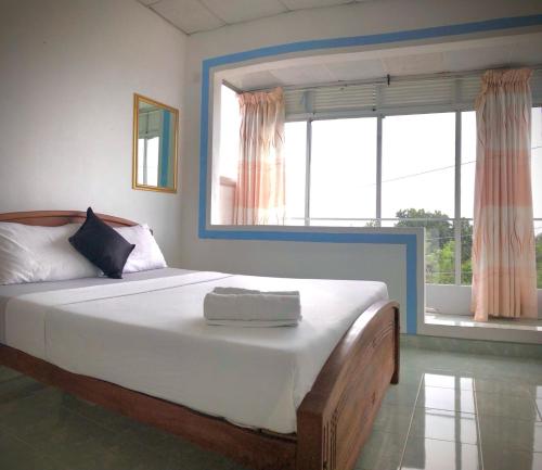 a bedroom with a large bed with a large window at GK Mount Villa Kandy in Kandy