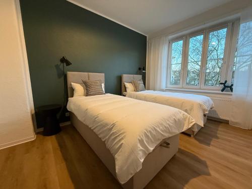 ein Schlafzimmer mit zwei Betten und einem Fenster in der Unterkunft Apartment 3 Eilenriede in Hannover