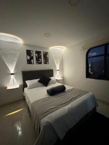 a bedroom with a large bed with two lamps at DHG Apartahotel in Pereira