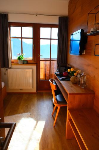 a room with a desk and a television in a room at Gmundnerberghaus - ROOMS in Altmünster