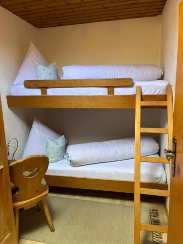 two bunk beds in a room with a chair at Schusterhof in Innsbruck
