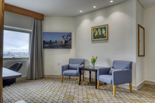 a room with two chairs and a table and a window at Geneva Hotel in Amman