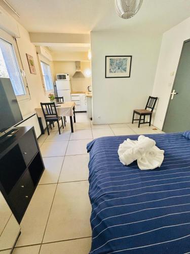 une chambre avec un lit bleu et une cuisine dans l'établissement Studio Thermotel 308, à Saint-Martin-dʼUriage
