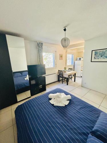 - une chambre avec un lit bleu et une serviette dans l'établissement Studio Thermotel 308, à Saint-Martin-dʼUriage