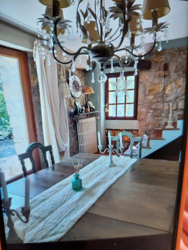 une salle à manger avec une table et un lustre dans l'établissement La BERGERIE entre mer et montagne, à Bargemon