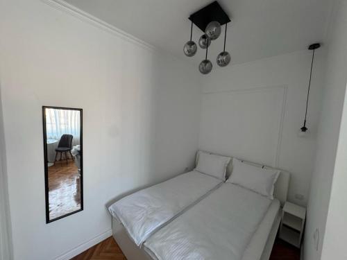 a white bed in a room with a mirror at Moft Hotel Apartments Free Parking Self Check-In in Oradea