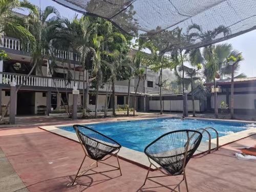 two chairs sitting in front of a swimming pool at 5 Beach Suite wpool sea access in La Libertad