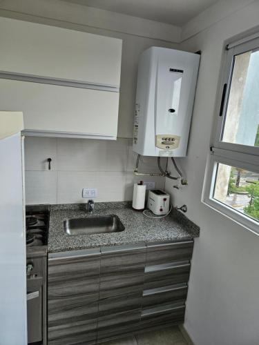 ブエノスアイレスにあるApartamento frente al Parque Sarmientoの小さなキッチン(シンク付)、窓