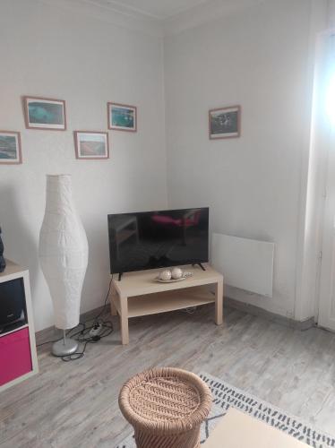 un salon avec une télévision et une table dans l'établissement Bretagne évasion, à Plouhinec