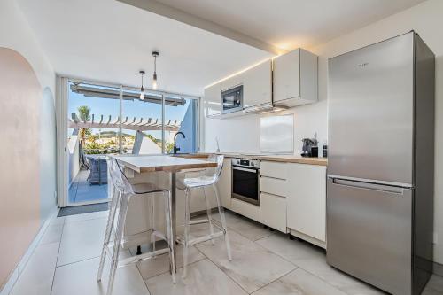 une cuisine avec des appareils blancs et une grande fenêtre dans l'établissement The Wave Village Naturiste Port Ambonne Cap d Agde, au Cap d'Agde