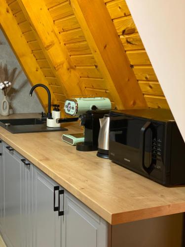a kitchen counter with a microwave and a sink at Cabana Forestia - ciubăr inclus in Copalnic Mănăştur