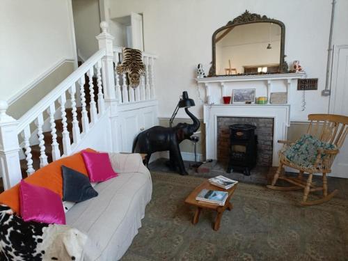 a living room with a white couch and a fireplace at The Studio Trewarveneth Manor Farm TR185NF in Newlyn