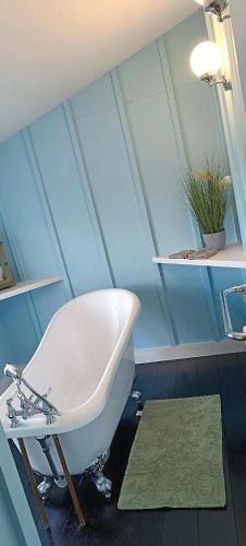 a bathroom with a white bath tub in a attic at The Studio Trewarveneth Manor Farm TR185NF in Newlyn