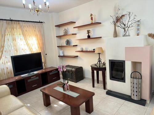 a living room with a tv and a fireplace at villa Maria in Neo Chorio