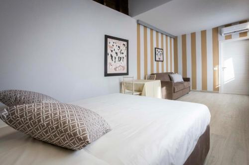 a bedroom with a large bed and a couch at Foresteria Lombarda GELSO BIANCO in Cogliate