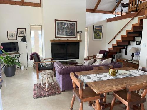 a living room with a couch and a table at Quince Cottage in Goedverwag