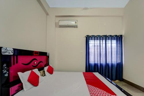 a bedroom with a bed with a red and black headboard at Hotel O Gangotri Inn in Gulzārbāgh