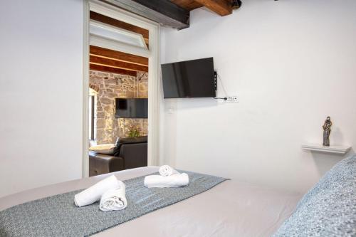 Apartman Sun 1 في شيبينيك: غرفة نوم بها سرير وتلفزيون على الحائط