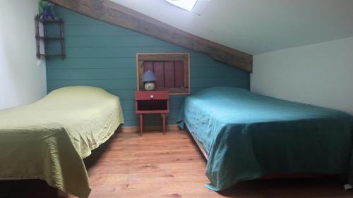 une chambre avec deux lits et une table avec une lampe dans l'établissement amets politak, à Hasparren