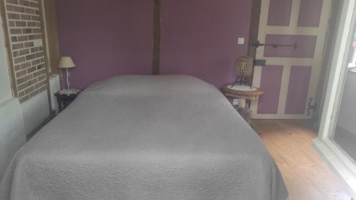 - une chambre avec un lit blanc et un mur violet dans l'établissement amets politak, à Hasparren