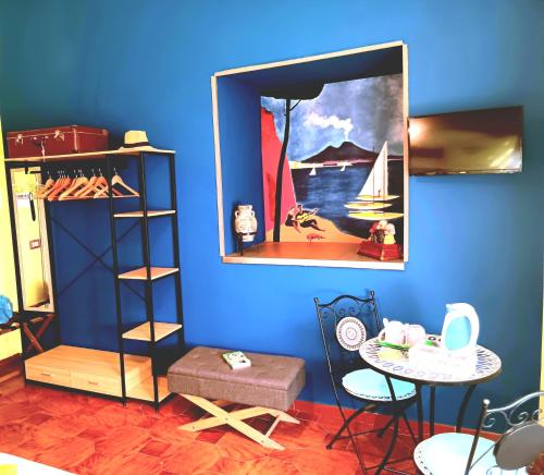 Habitación azul con una mesa y una foto en la pared en Non ci resta che Napoli, en Nápoles