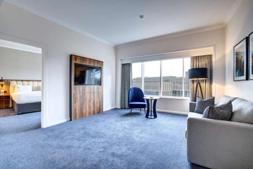 a hotel room with a couch and a bed and a window at Radisson Blu Hotel, Durham in Durham