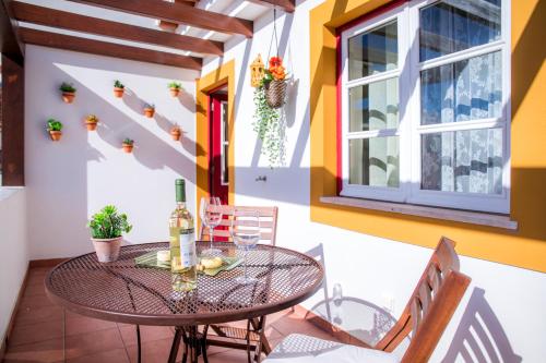 a balcony with a table and chairs and a window at Casinha D'Avó Guesthouse in Lagos