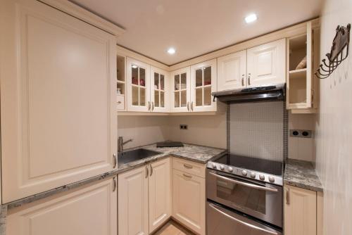 une cuisine avec des armoires blanches et des appareils en acier inoxydable dans l'établissement Bucolique, à Paris