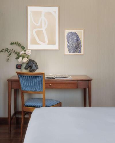 a desk with a chair and a cat sitting at it at WorldHotel Casati 18 in Milan