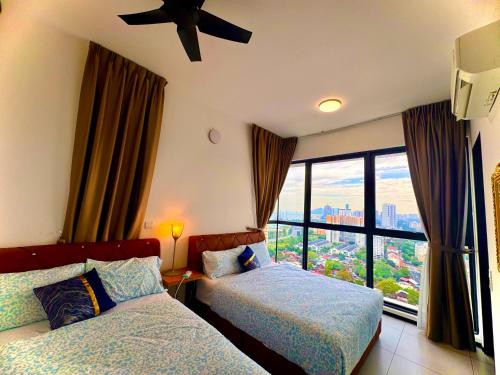 Una habitación de hotel con dos camas y una ventana. en Spacious 2BR Stay 5 Queen Beds for Large Groups, en Jelutong