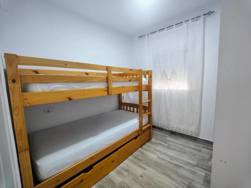 ein Schlafzimmer mit zwei Etagenbetten und einem Fenster in der Unterkunft Huelin playa in Málaga