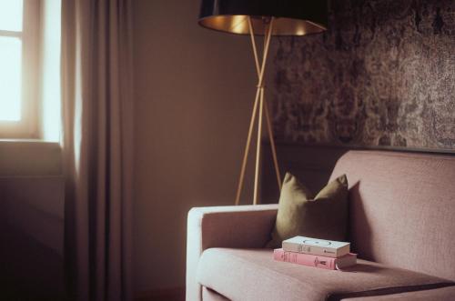 a lamp and a couch with boxes on it at Romantik Spa Hotel Elixhauser Wirt in Elixhausen