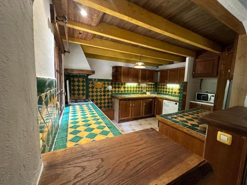 - une cuisine avec des placards en bois et du carrelage coloré sur les murs dans l'établissement La Ferme du Port d'Enveaux, à Saint-Vincent-de-Cosse