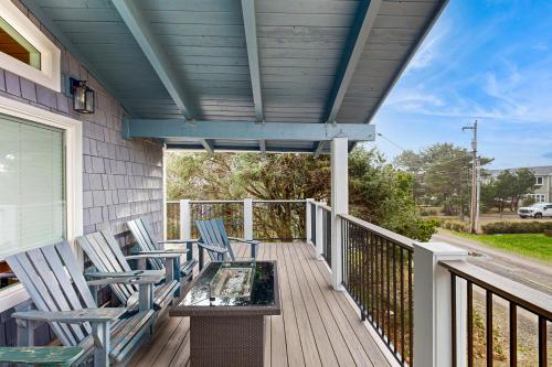 a porch with rocking chairs and a table on it at The Sand Ranch in Rockaway Beach