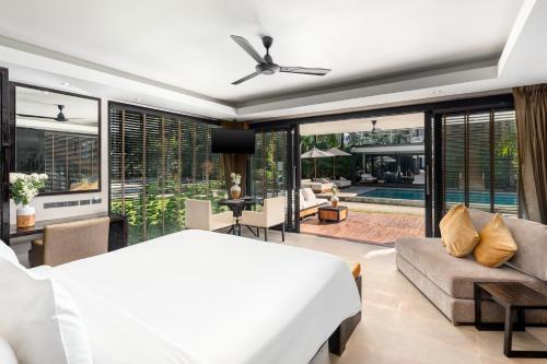 a bedroom with a bed and a living room at Nikki Beach Resort & Spa Koh Samui in Lipa Noi