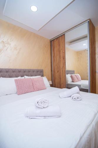 a bedroom with a large white bed with towels on it at Zlatiborski Konaci in Zlatibor