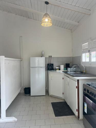 una cucina con un frigorifero bianco e una stufa di Logement à trois rivières à 5min de l embarcadère a Trois-Rivières