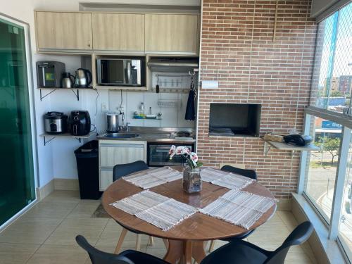 カルダス・ノバスにあるApartamento confortável em caldas novas com espaço aquático, 6 piscinas , 3 hidromassagem , Bar e Restaurante , Sauna , espaço kidsのキッチン(木製テーブル、椅子、テーブル付)
