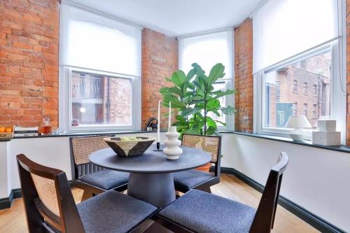 a dining room with a table and chairs and windows at 2 bed Luxury Apartment, Parking, Gym, Concierge in Manchester