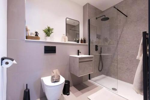 a bathroom with a shower and a toilet and a sink at 2 bed Luxury Apartment, Parking, Gym, Concierge in Manchester