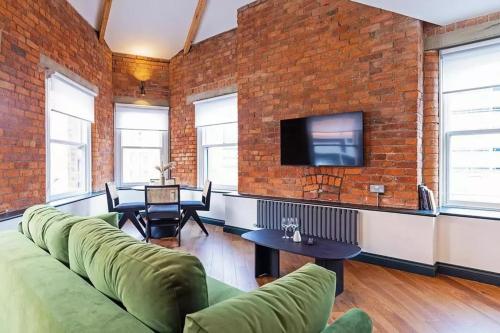 a living room with a couch and a brick wall at 2 bed Luxury Apartment, Parking, Gym, Concierge in Manchester