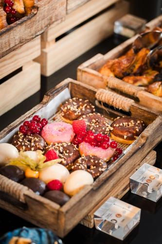 two baskets filled with different types of donuts and pastries at Hospes Palacio del Bailio, a Member of Design Hotels in Córdoba