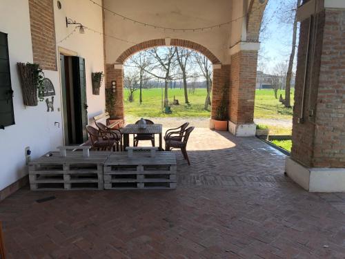 a patio with a table and chairs and an archway at Agriturismo Villa Greggio in Casalserugo
