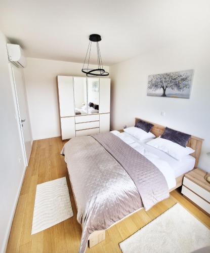a bedroom with a large bed and a mirror at Apartment Queen, self check-in, free private garage parking in Karlovac