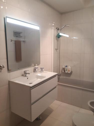 a white bathroom with a sink and a shower at Amorosa Beach Sun And Sea in Viana do Castelo
