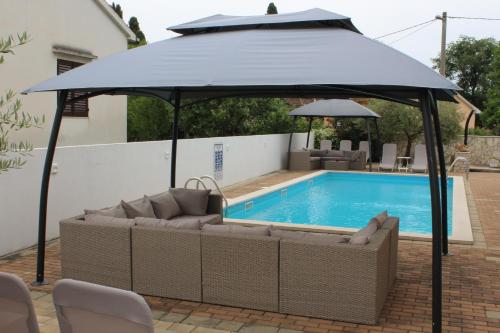 a large blue umbrella over a swimming pool at Apartments Kimm's Hideaway in Poreč