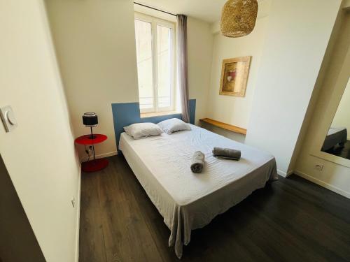 a bedroom with a bed in a room with a window at Le Prestige de la Mairie in Bourg-lès-Valence