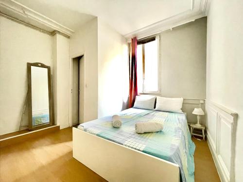 une chambre avec un lit et une grande fenêtre dans l'établissement Charming Haussmannian Apartment HyperCentre, à Rouen