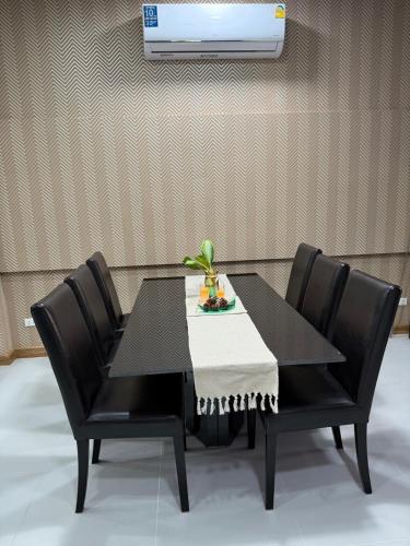 a black dining room table with four black chairs at Homey At The Dam, Private House in Ban Ta Khun