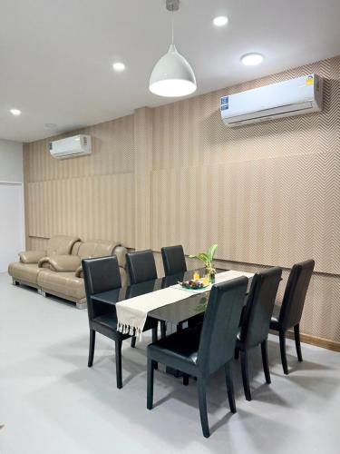 a dining room with a table and chairs and a couch at Homey At The Dam, Private House in Ban Ta Khun